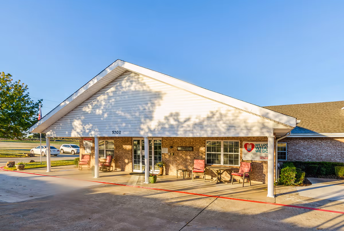 Single-story senior living facility with a covered front entrance and outdoor seating.