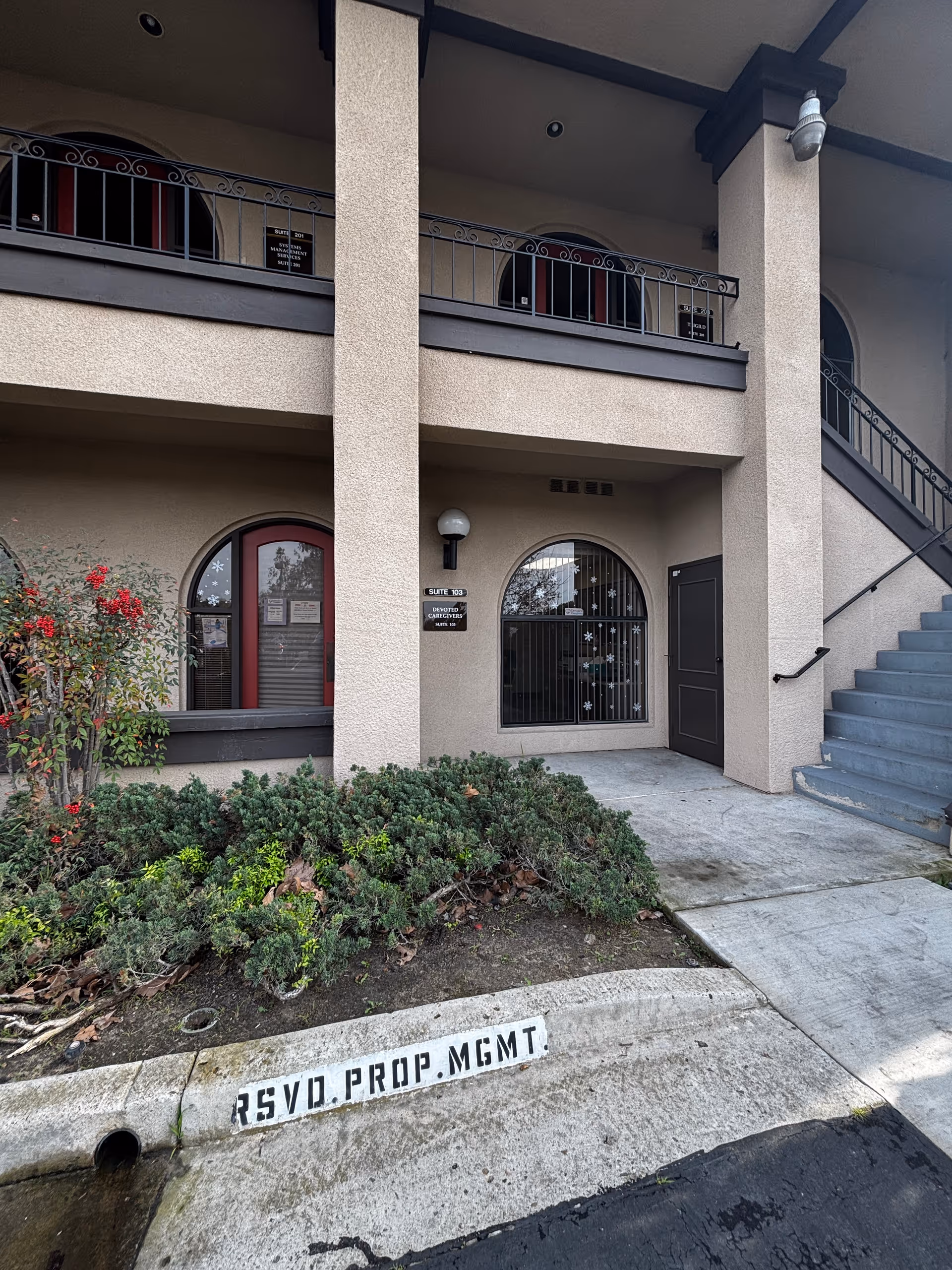 Exterior view of Devoted Caregivers senior facility entrance with stairs.