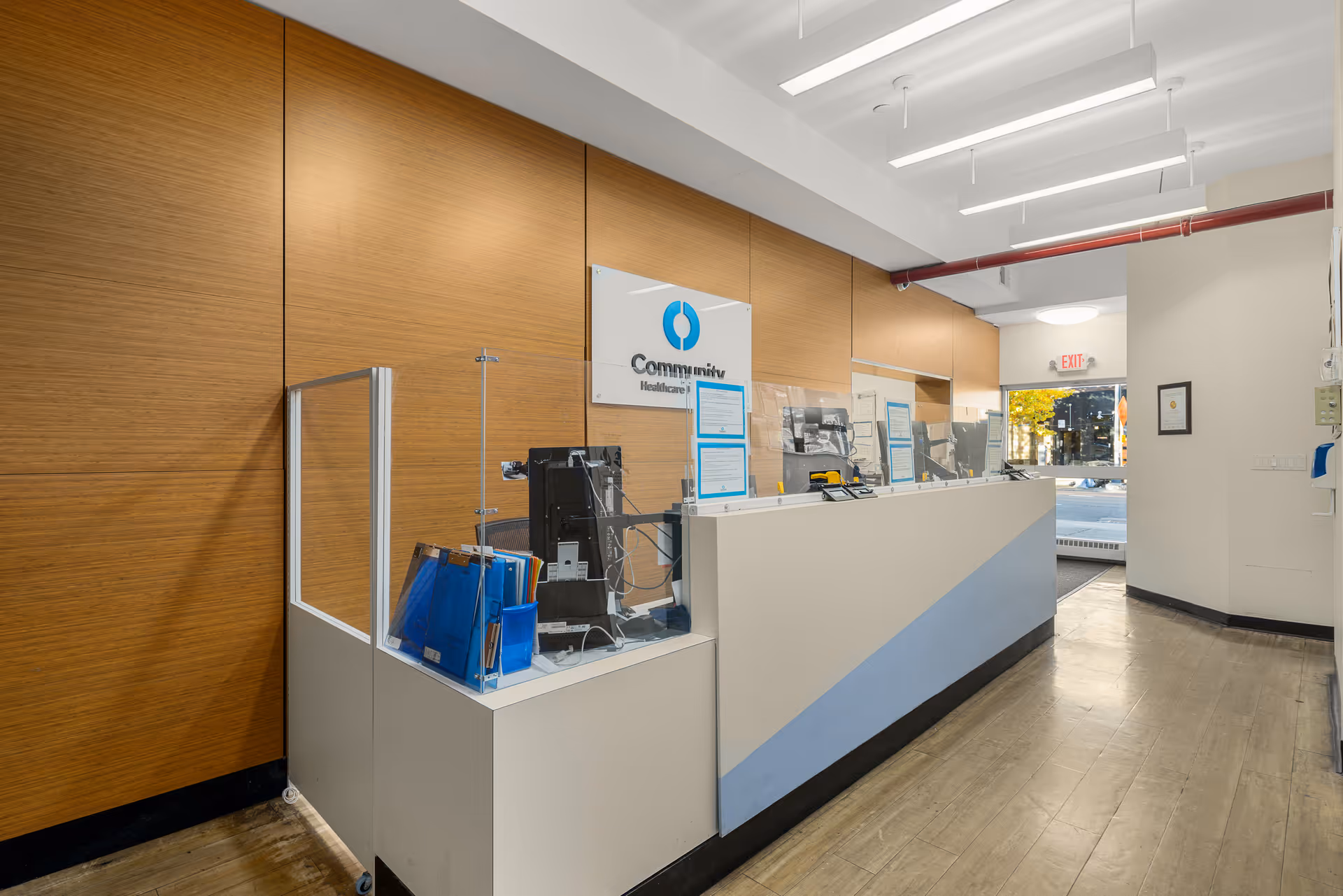 Interior reception desk with wood-paneled walls and a Community Healthcare Network sign.
