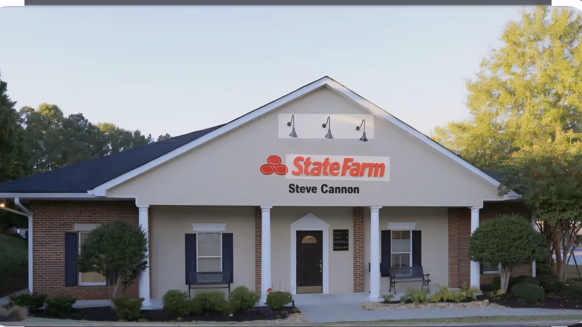 Front exterior of a single-story building with State Farm sign and columns.