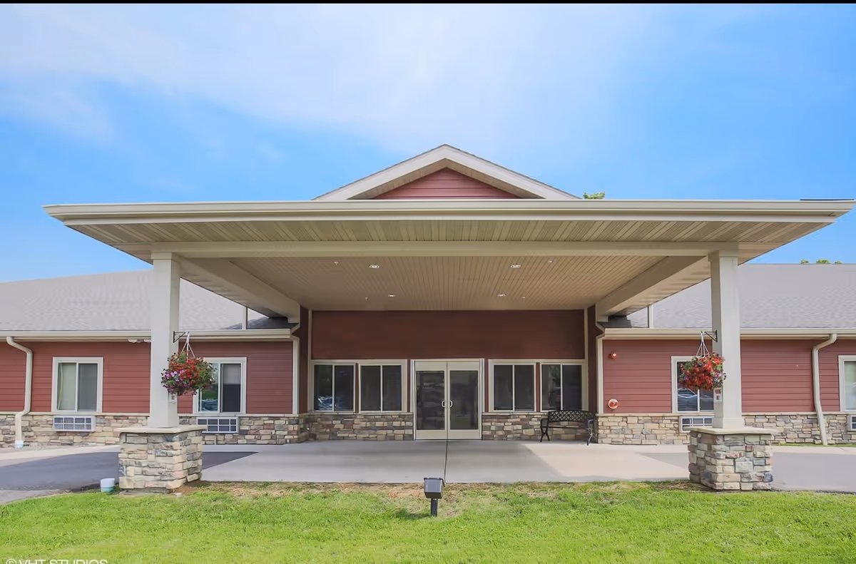 Exterior view of The Waterford at Park Falls front entrance under a covered porte-cochère.