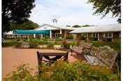 Avon Health Center exterior with brick building, green awnings, and outdoor seating in a courtyard.