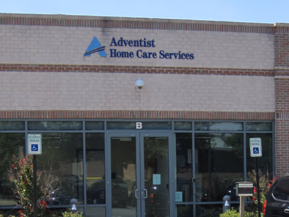 Exterior view of Adventist Home Care Services facility with glass doors and signage