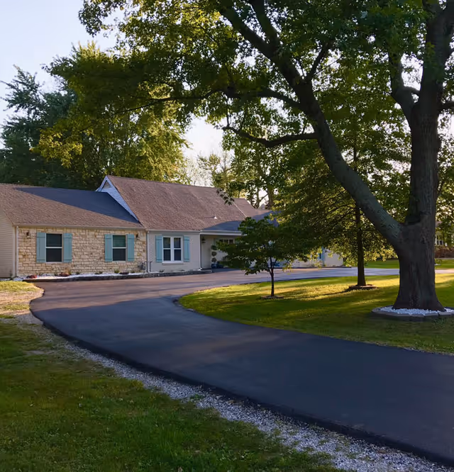 Exterior view of Emerald Ridge senior living facility with curved driveway and trees.