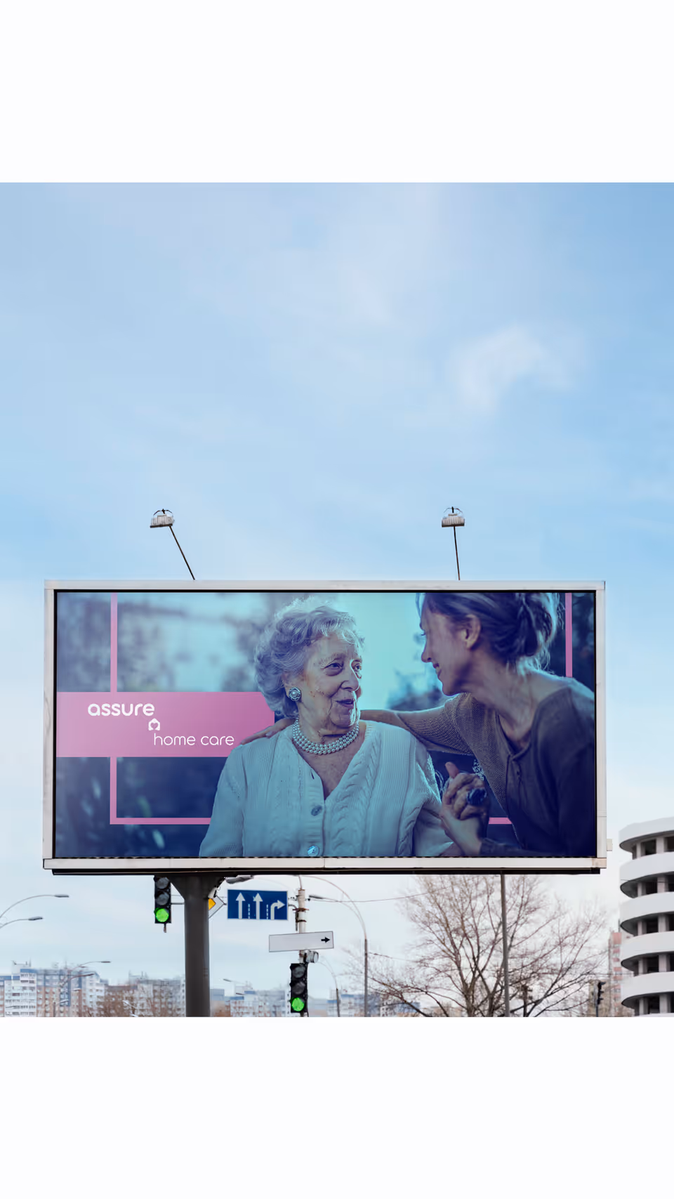 Outdoor billboard advertising Assure Home Care featuring an elderly woman with a caregiver.