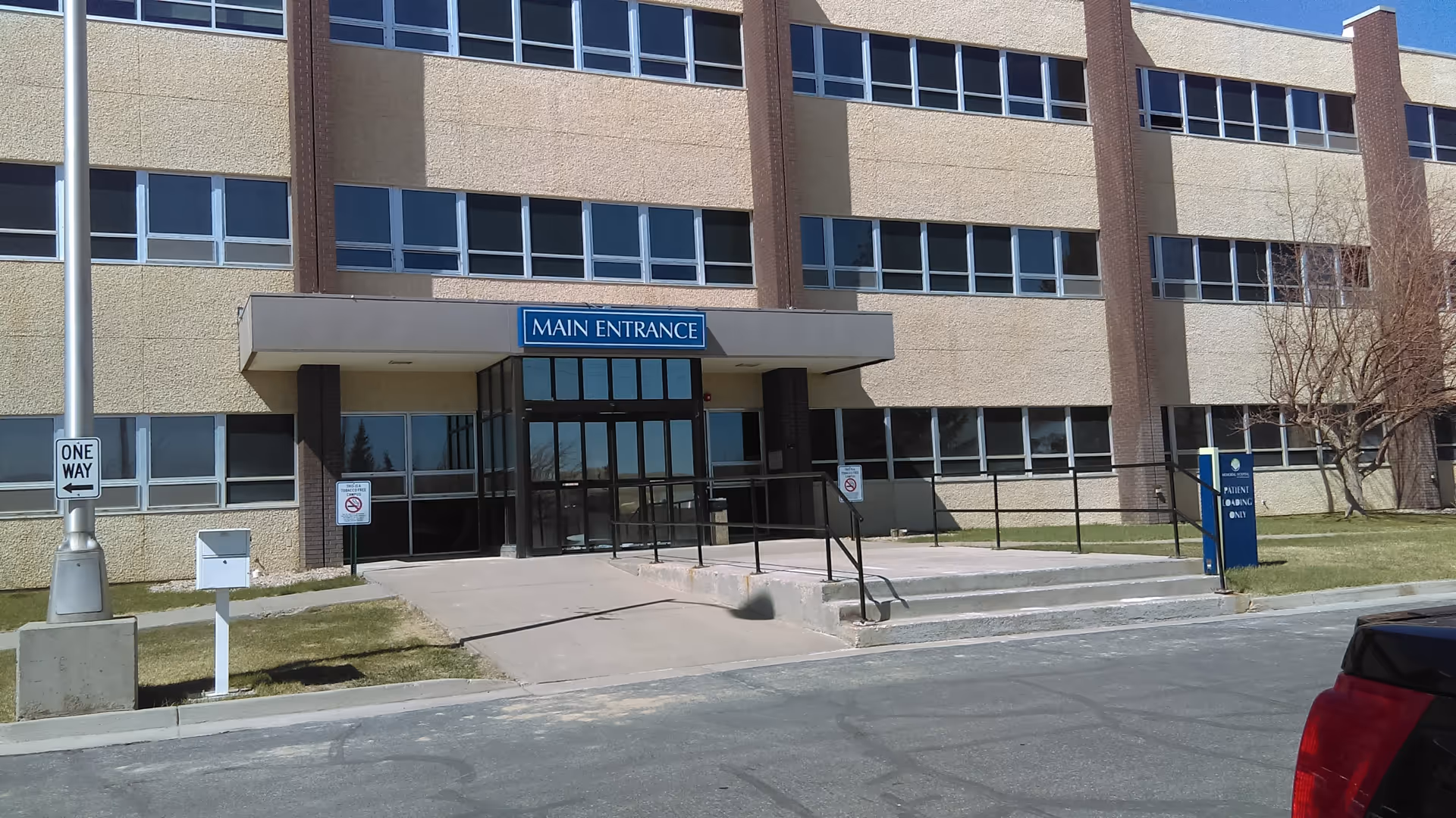 Exterior of a multi-story hospital building with a glass main entrance.