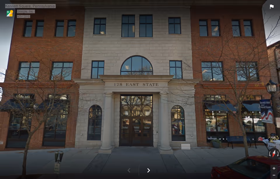 Front facade of a brick, multi-story building at 128 East State with arched entrance.