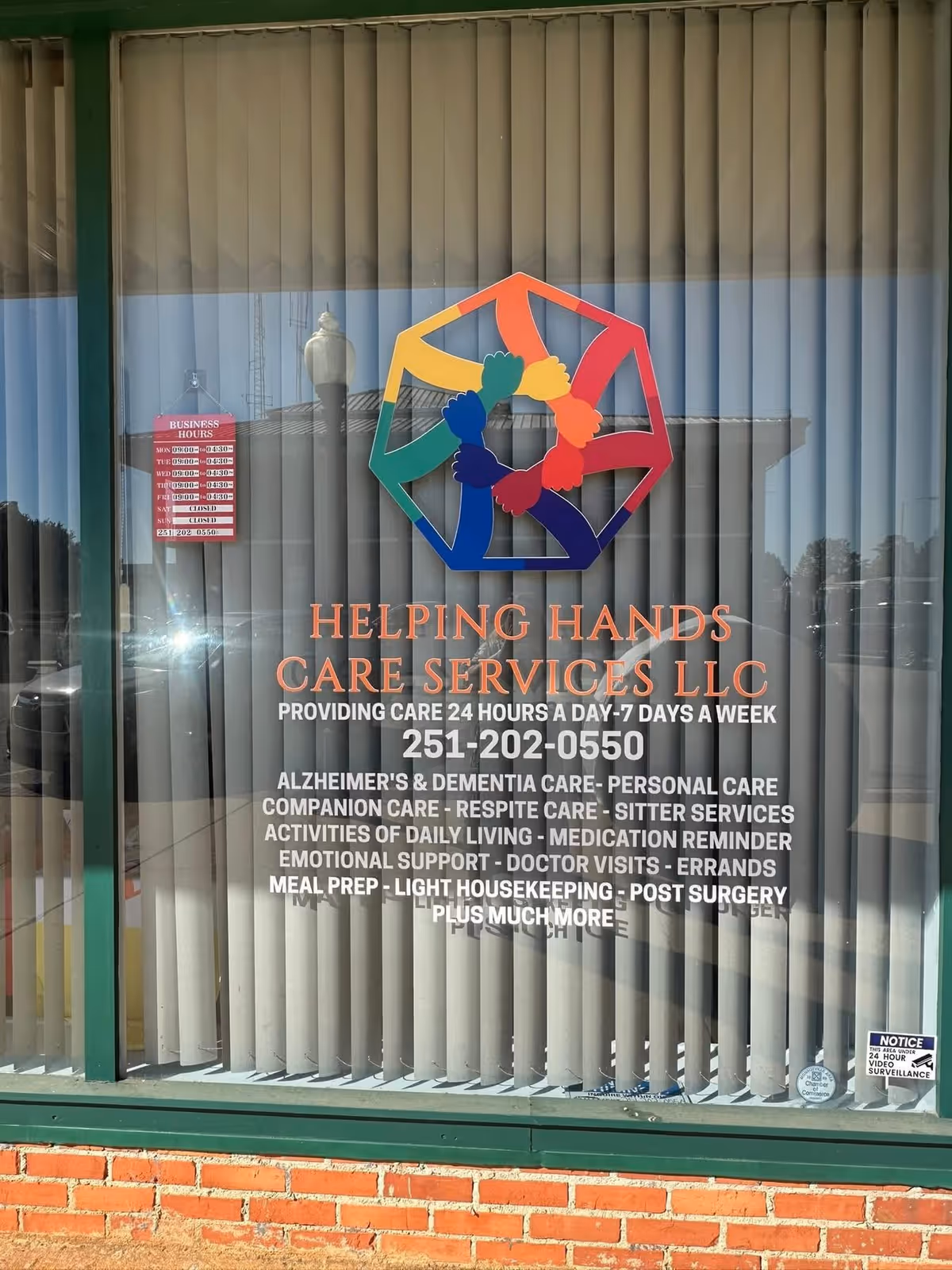 Front view of Helping Hands Care Services storefront with colorful logo on glass window.
