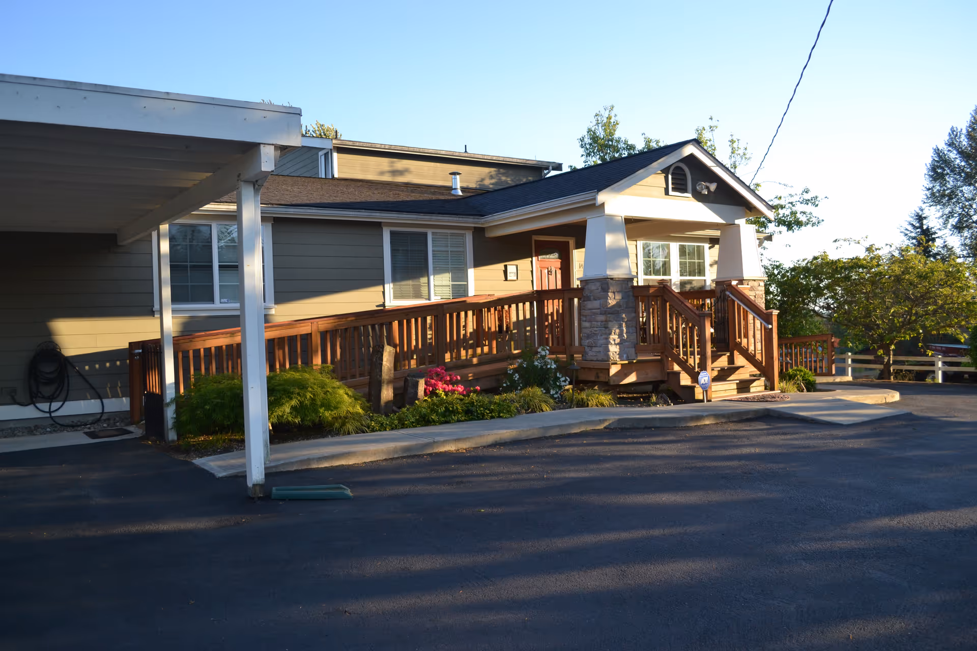 Exterior view of Wellspring front entrance with ramp, porch, and landscaping.