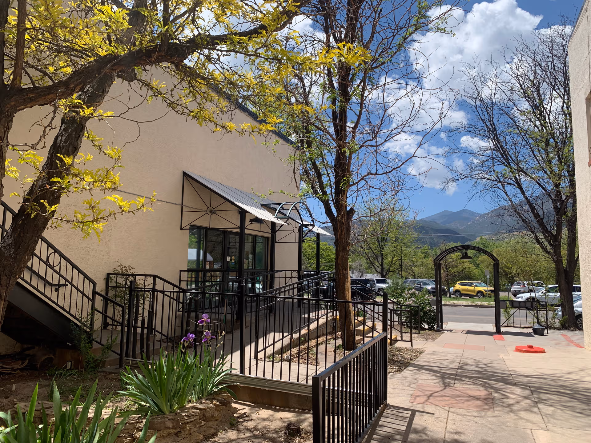 Exterior view of Sundance Skilled Nursing and Rehabilitation with ramp, trees, and distant mountains.