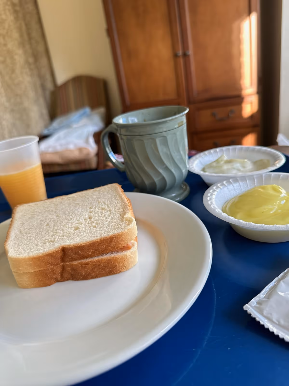 Toast slices with yogurt, juice, and a mug on a blue dining table.