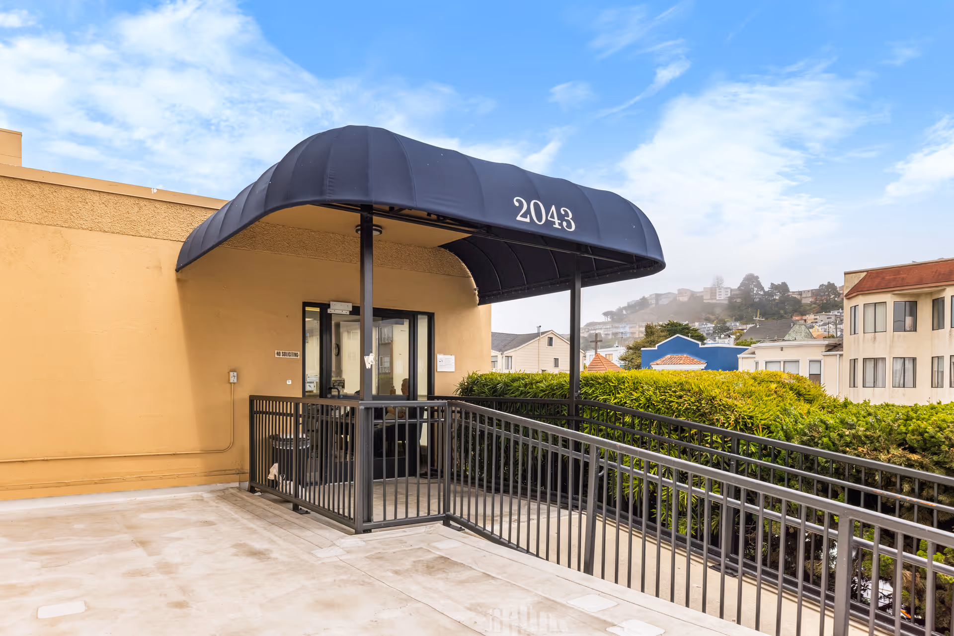 Exterior view of The Avenues Transitional Care Center entrance with a dark blue canopy.