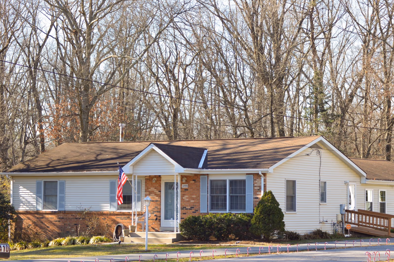 Front view of CRcare of Bonmdill, a single-story senior living facility with an American flag.