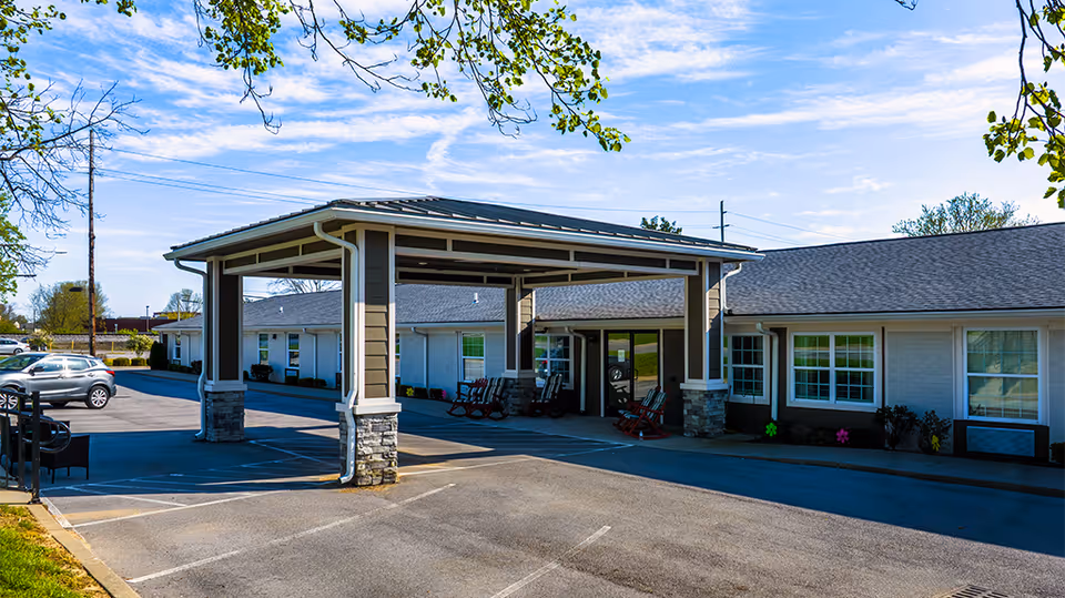 Exterior view of Creekside on Whipps Mill with a covered entrance and rocking chairs.