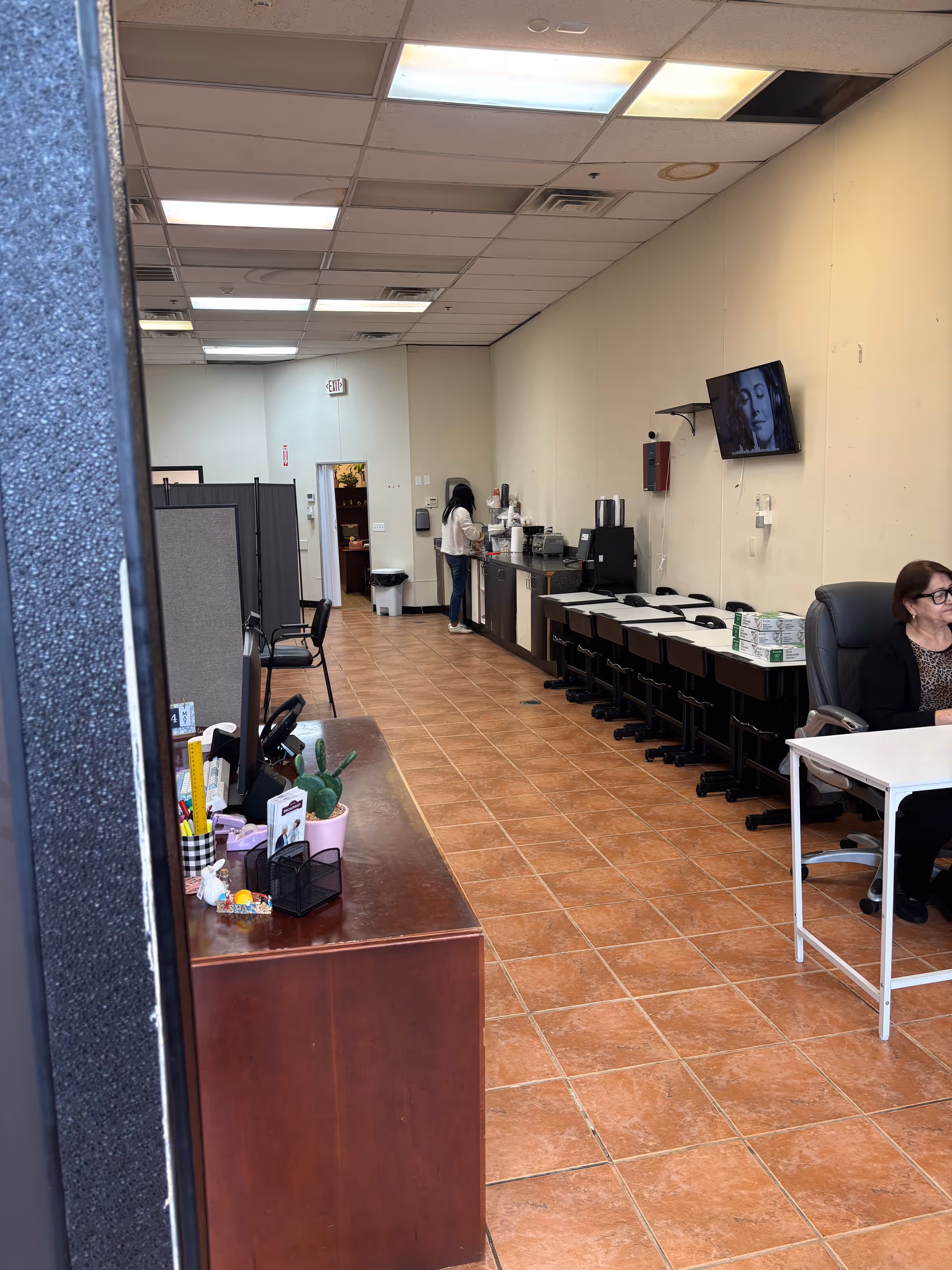 Interior corridor of a senior facility featuring a coffee station, desks, and seating along the wall.