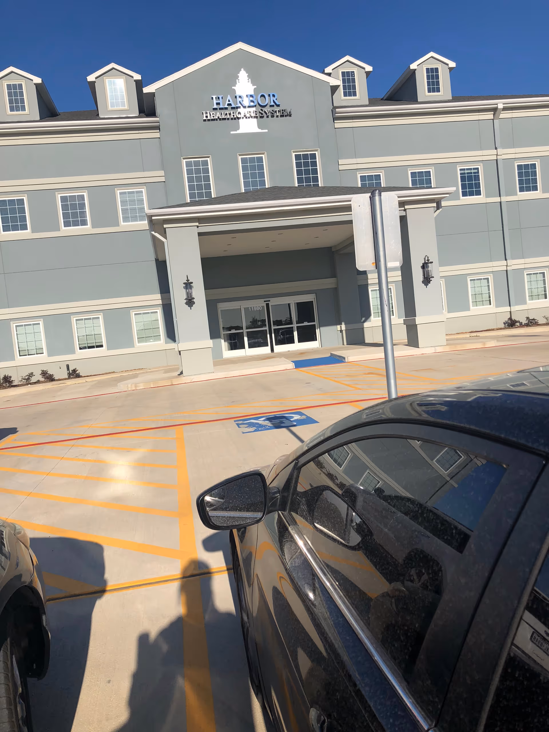 Front facade of Harbor Hospice of Beaumont building with parked cars in foreground