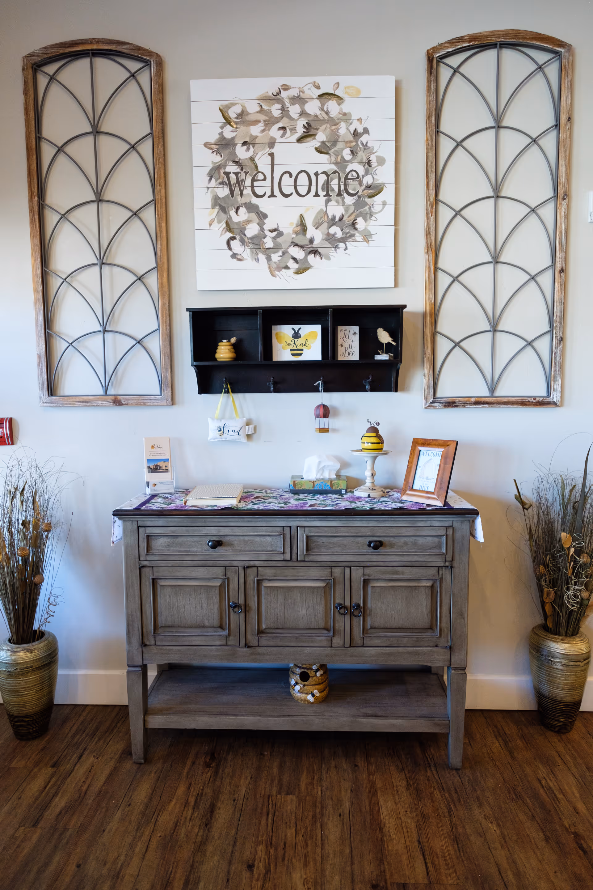Interior entryway featuring a wooden console, welcome sign, and arched wall panels.