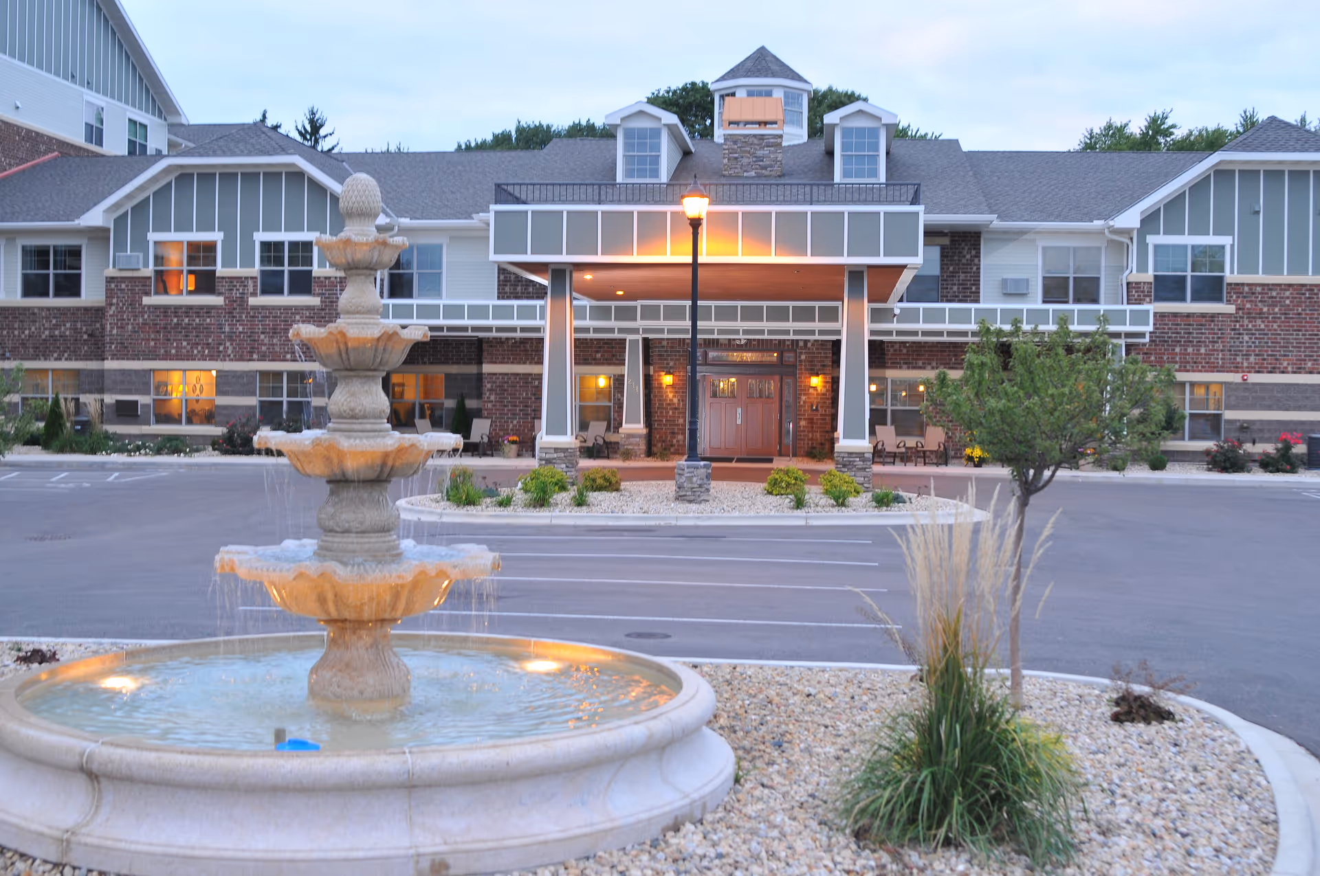 Front exterior view of Heritage Senior Campus with a stone fountain and entrance.