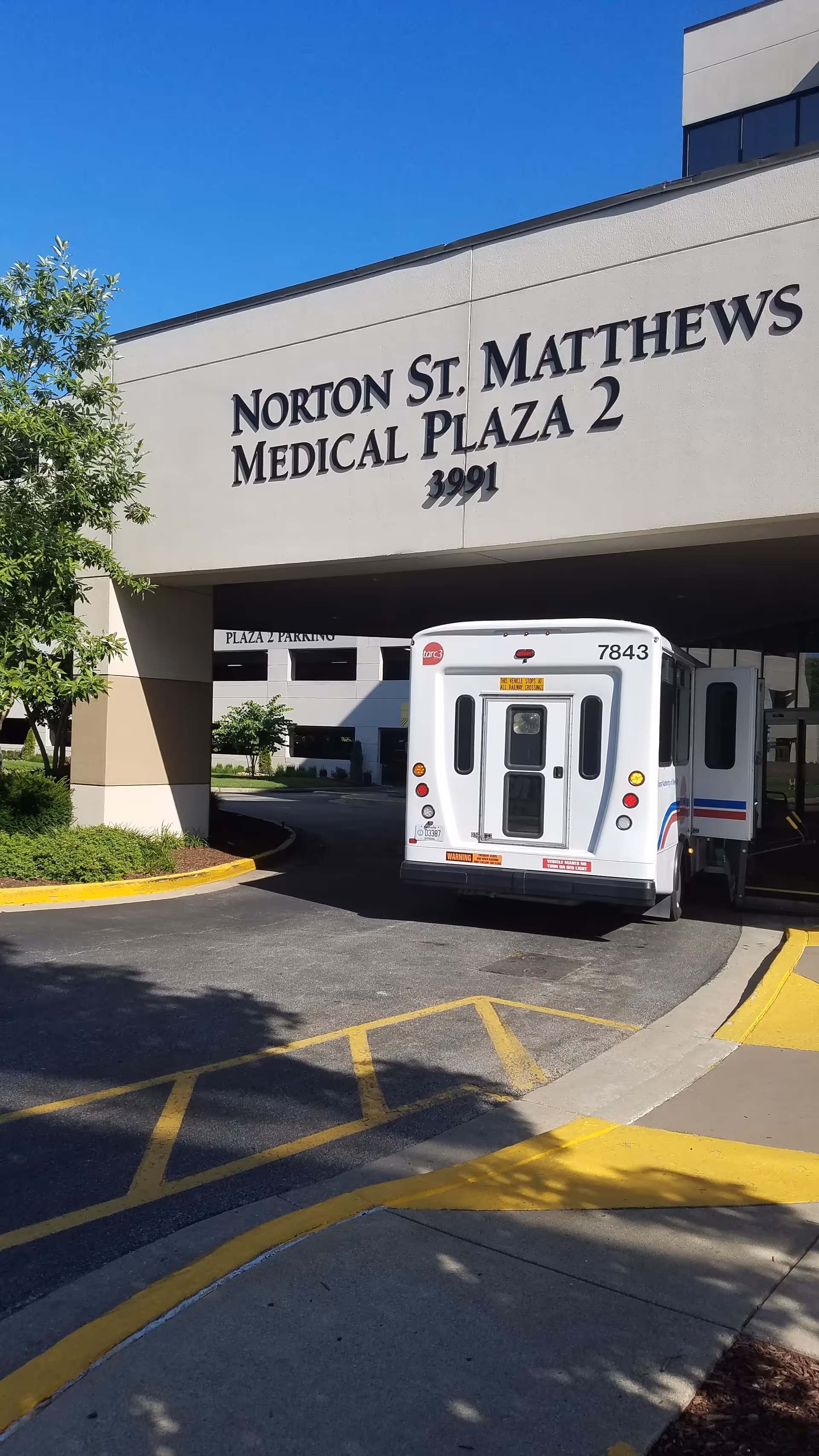 Front view of Norton St. Matthews Medical Plaza 2 with a white shuttle bus in driveway.