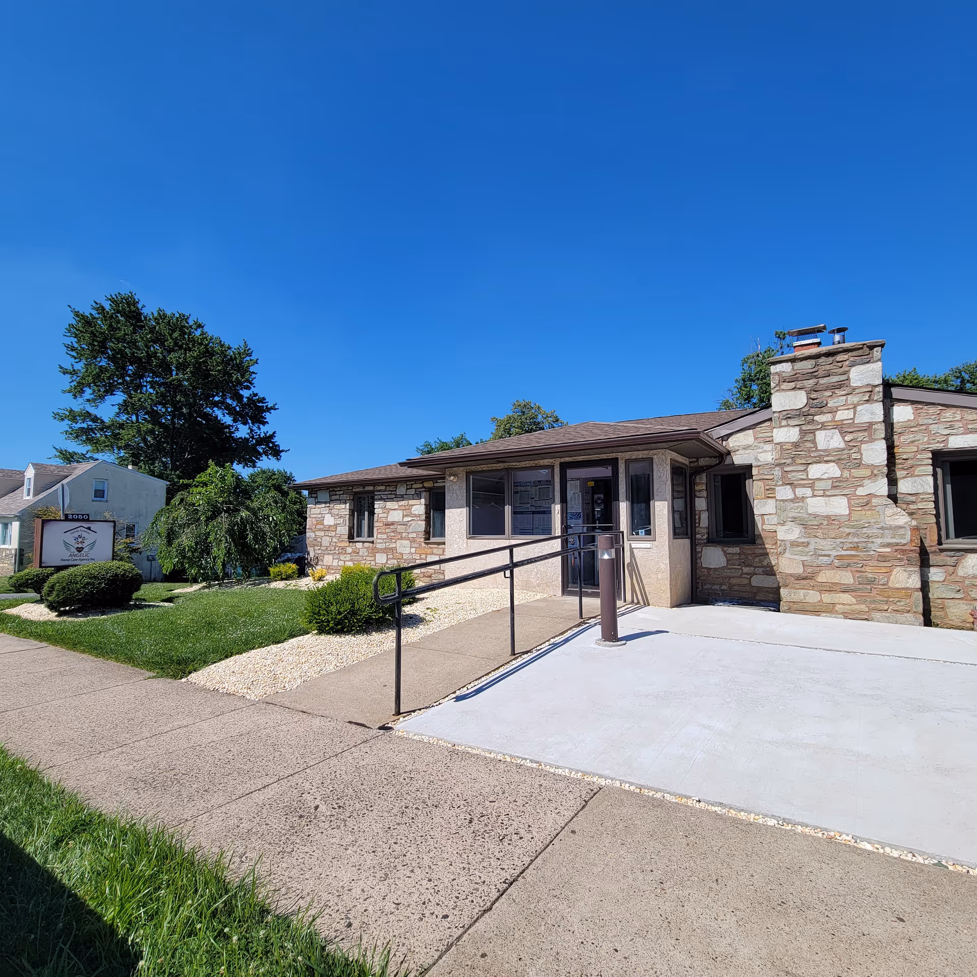 Front view of Angelic Home Care Agency Inc. building with ramp and stone exterior.