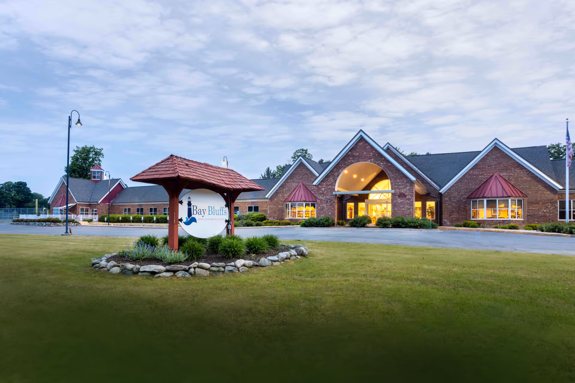 Exterior view of Bay Bluffs-Emmet Co Med Care Fac with brick entrance and sign.