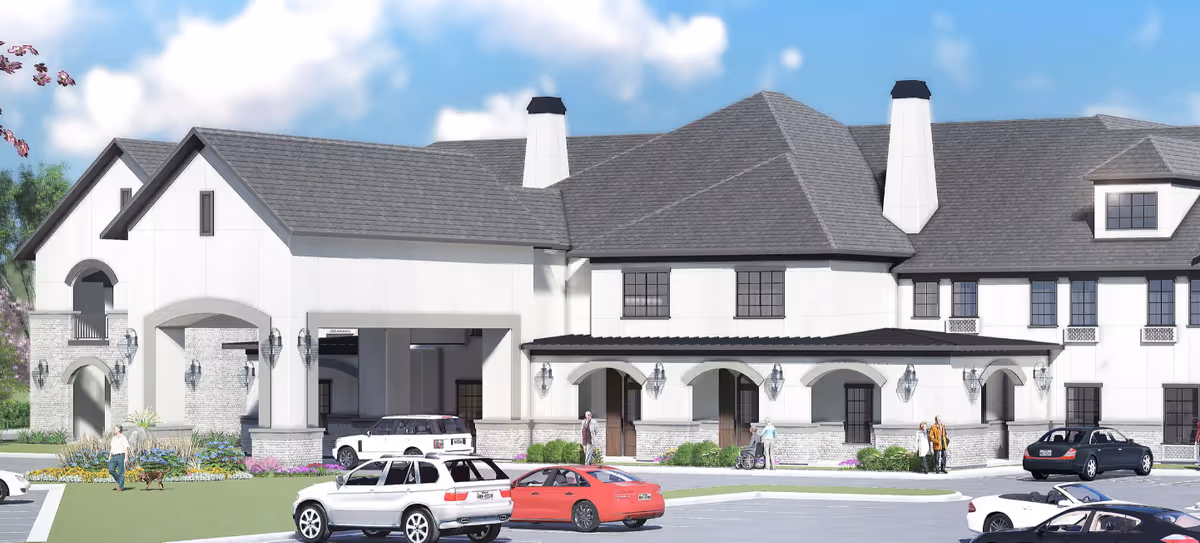A large, light-colored senior living facility facade with arched entrances and parked cars.