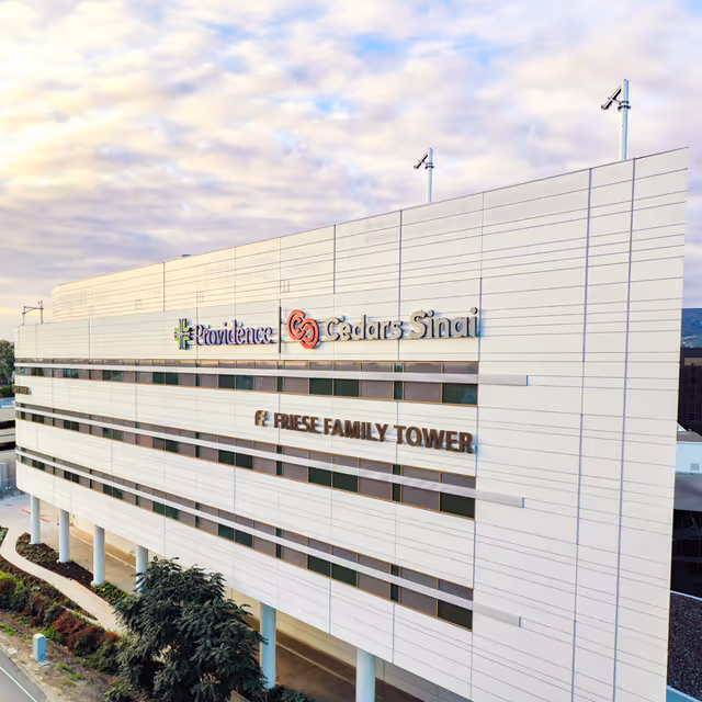 Exterior view of a modern medical building with Providence and Cedars-Sinai signage.