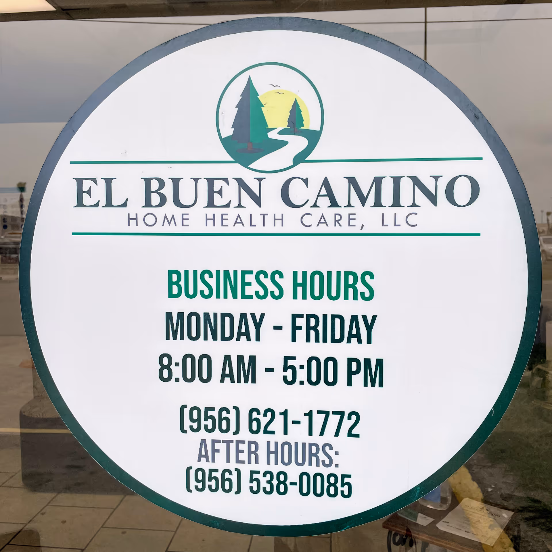 Circular sign on glass storefront reads El Buen Camino Home Health Care with hours.