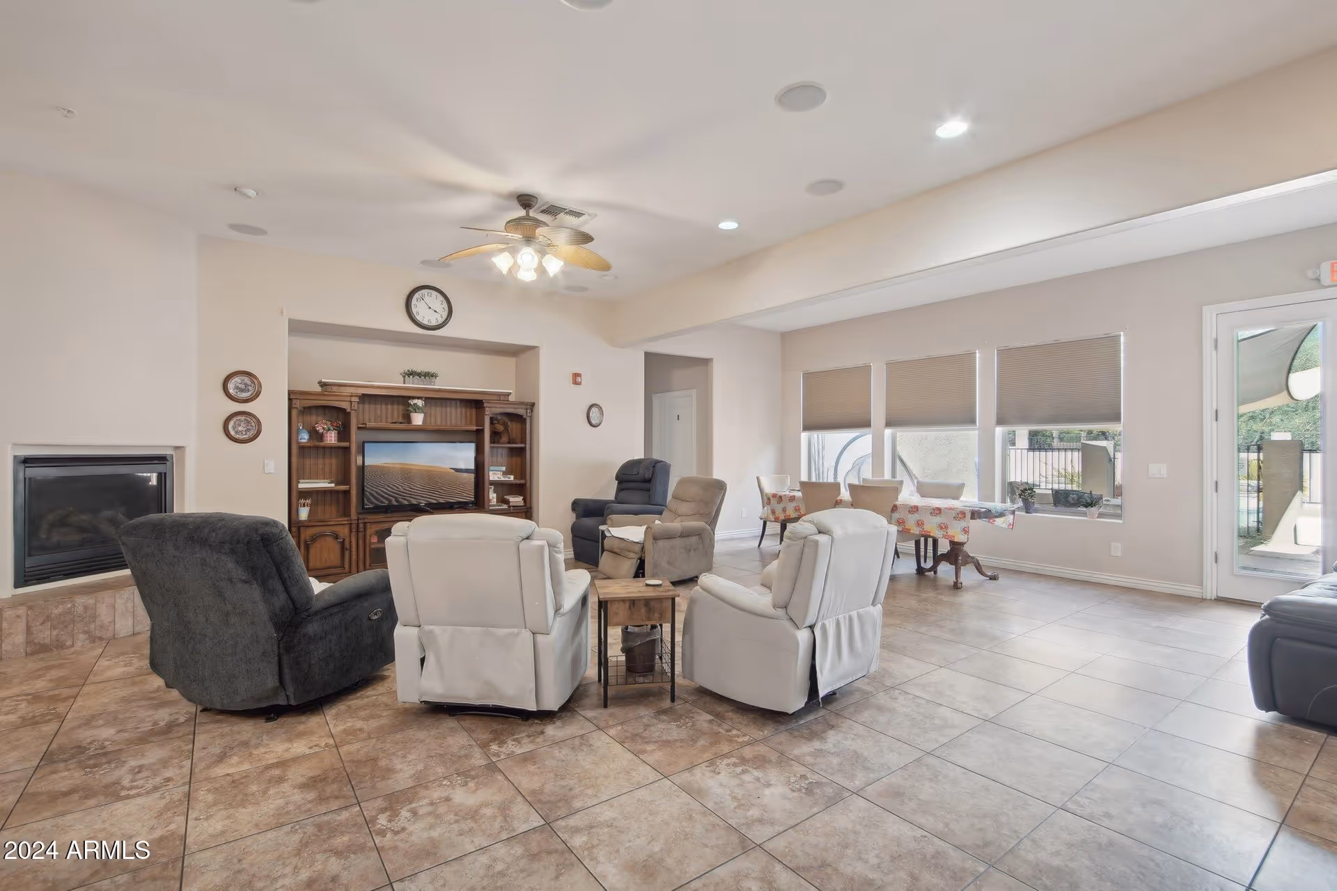 Spacious senior living lounge with recliners, a fireplace, and a TV entertainment center.