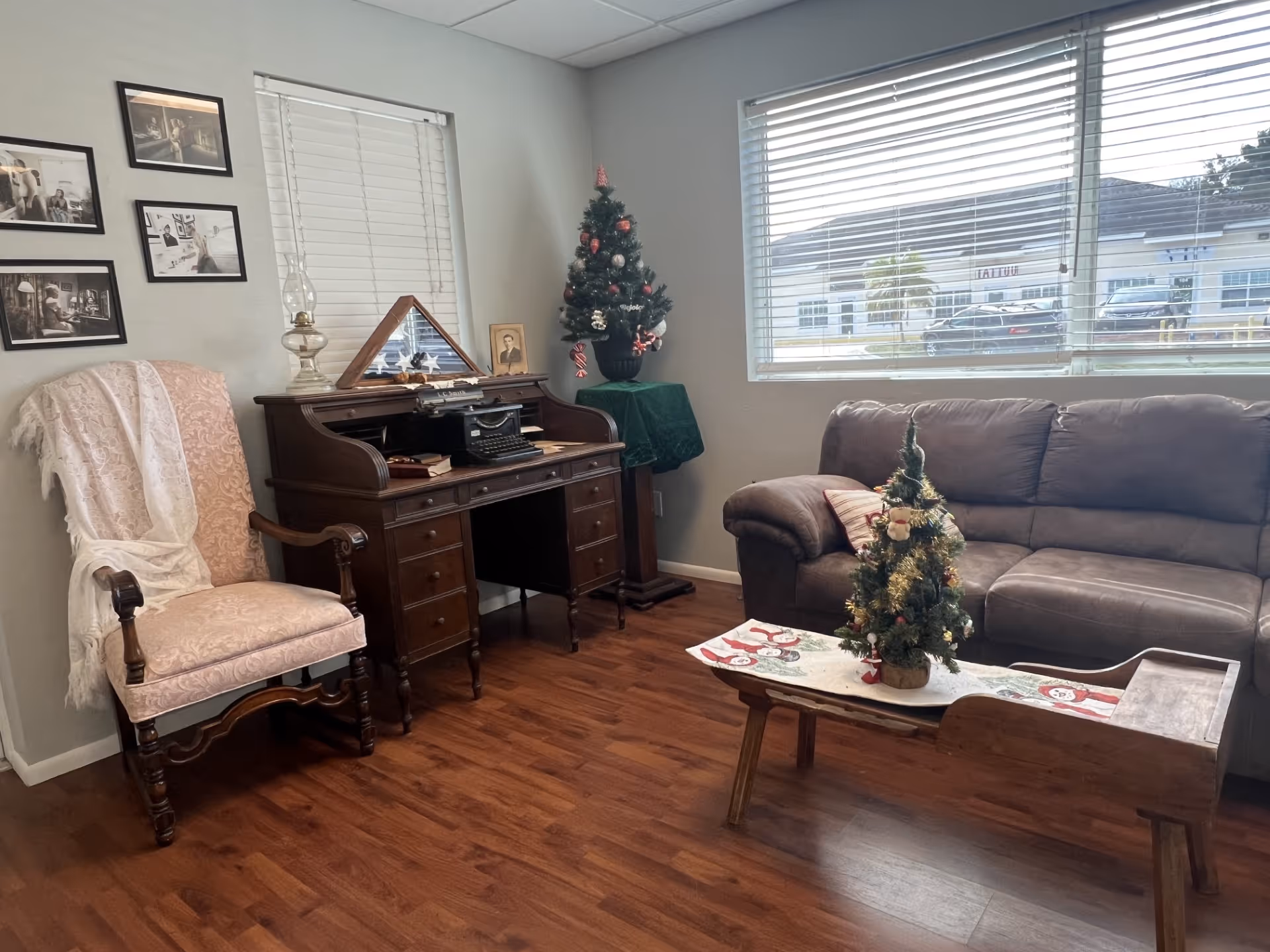 Cozy living room with a wooden desk, vintage chair, sofa, coffee table, and Christmas decor.