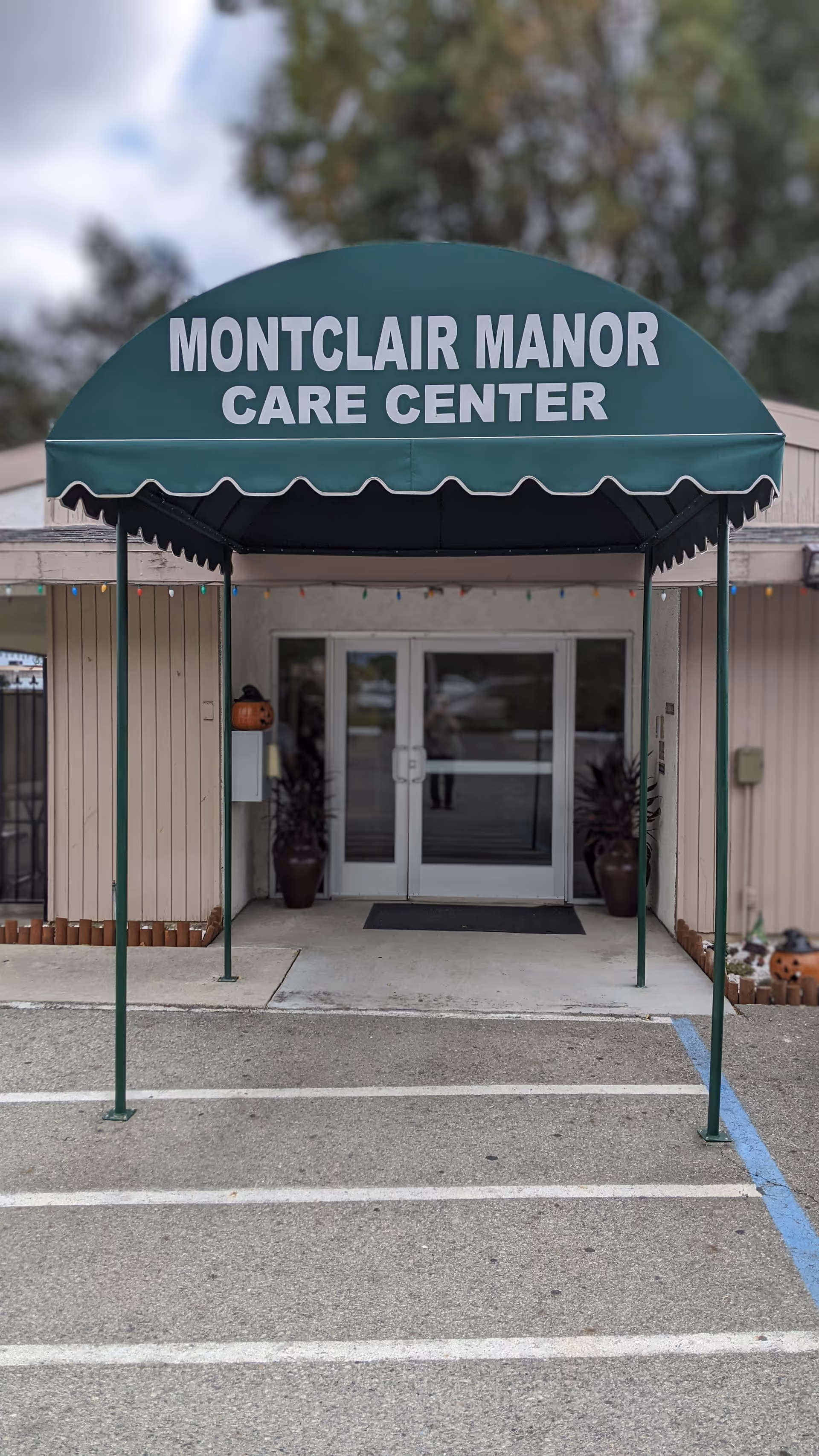 Front entrance of Montclair Manor Care Center with a green canopy and double doors.