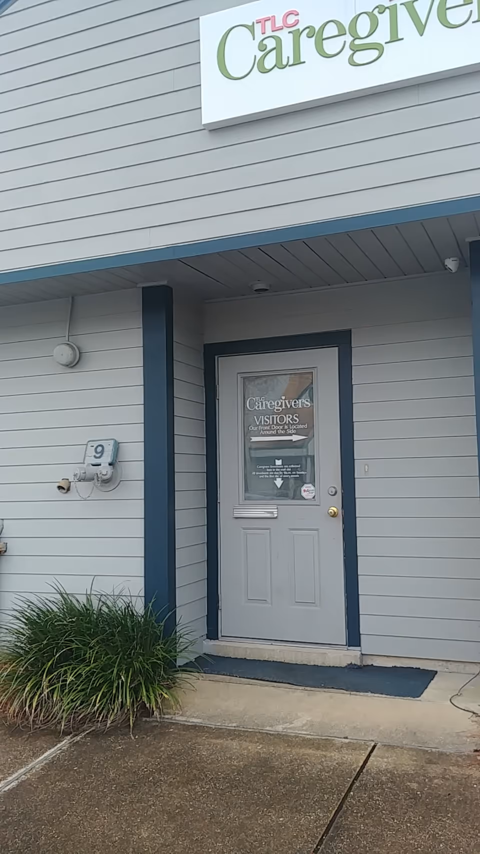 Exterior view of TLC Caregivers entrance with front door and sign.