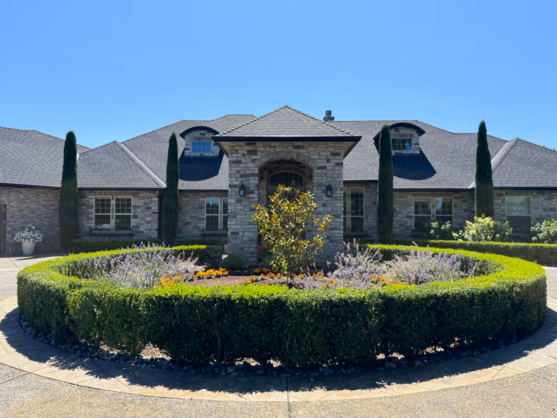 Stone-facade senior living facility with circular driveway and manicured landscaping.