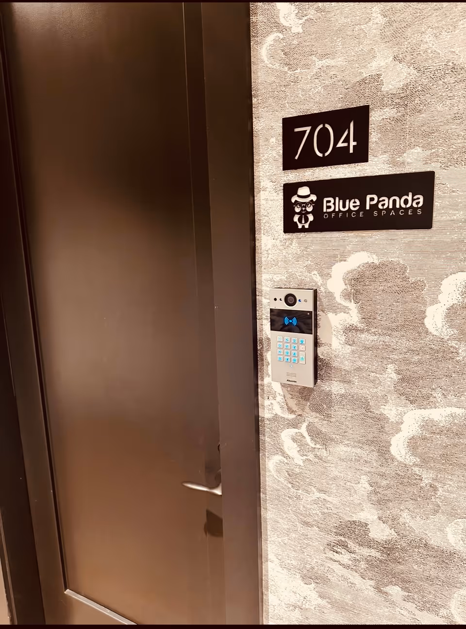 Interior door with number 704 and a keypad access beside patterned wall.