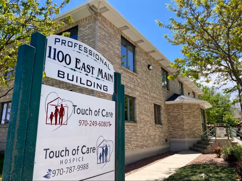 Exterior brick building with Touch of Care Hospice and East Main Building signs.