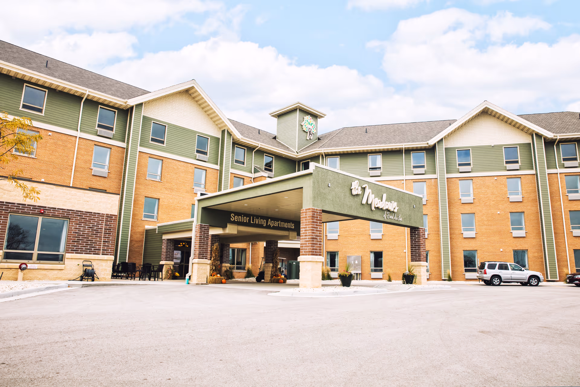 Exterior view of The Meadows of Fond du Lac senior living building with a covered entrance.