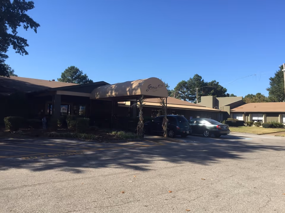 Exterior view of Grace Healthcare of Cordova with the entrance canopy and parked cars.