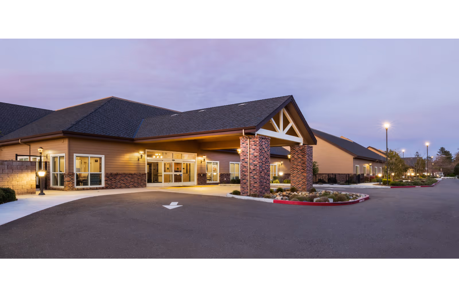 Shadowbrook Post Acute exterior at dusk with welcoming entrance and brick pillars.