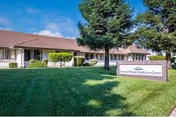 Front exterior view of Diamond Ridge Healthcare Center with a manicured lawn and sign.