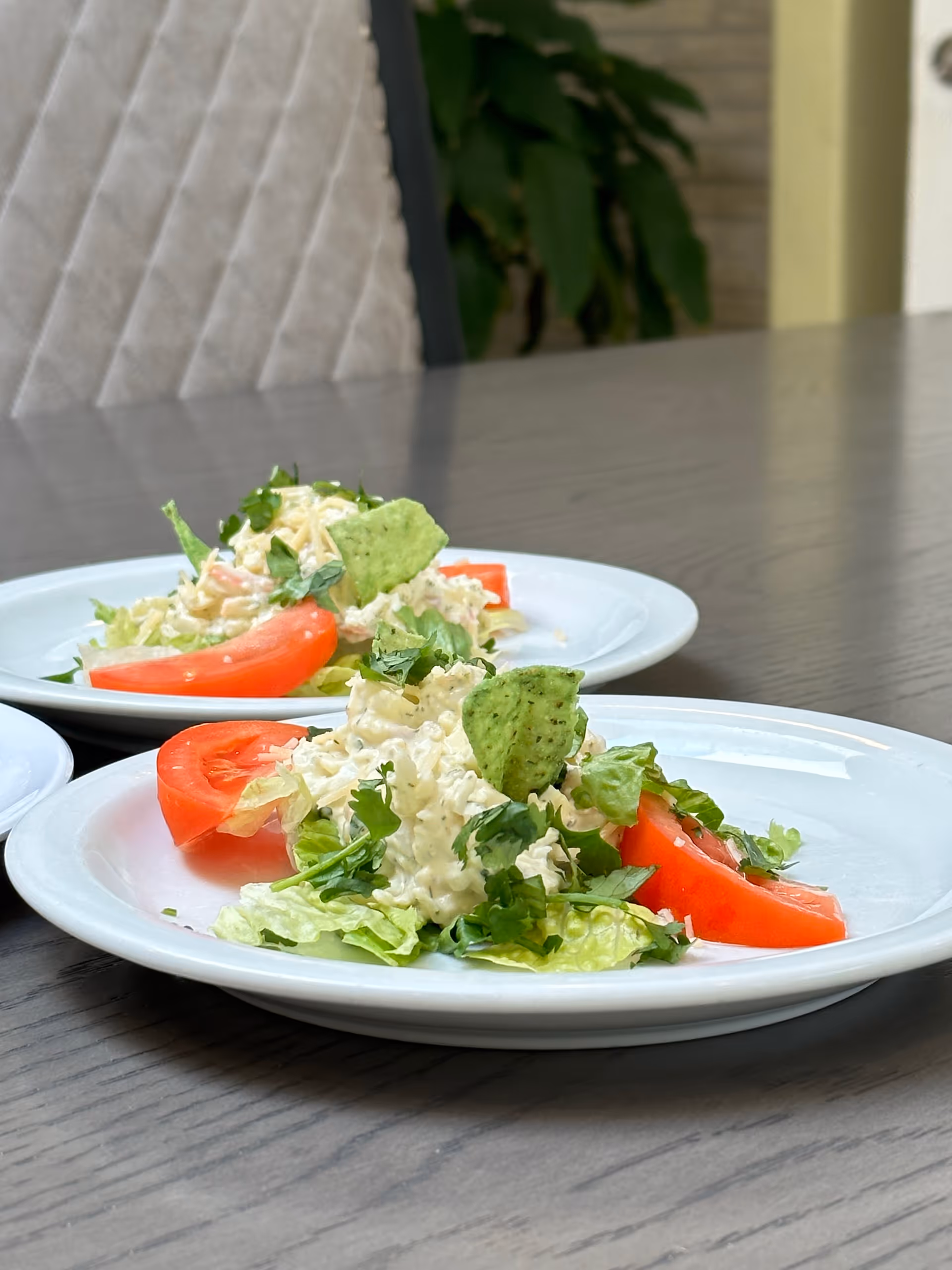 Two plated salads on a dining table in a senior living dining area.