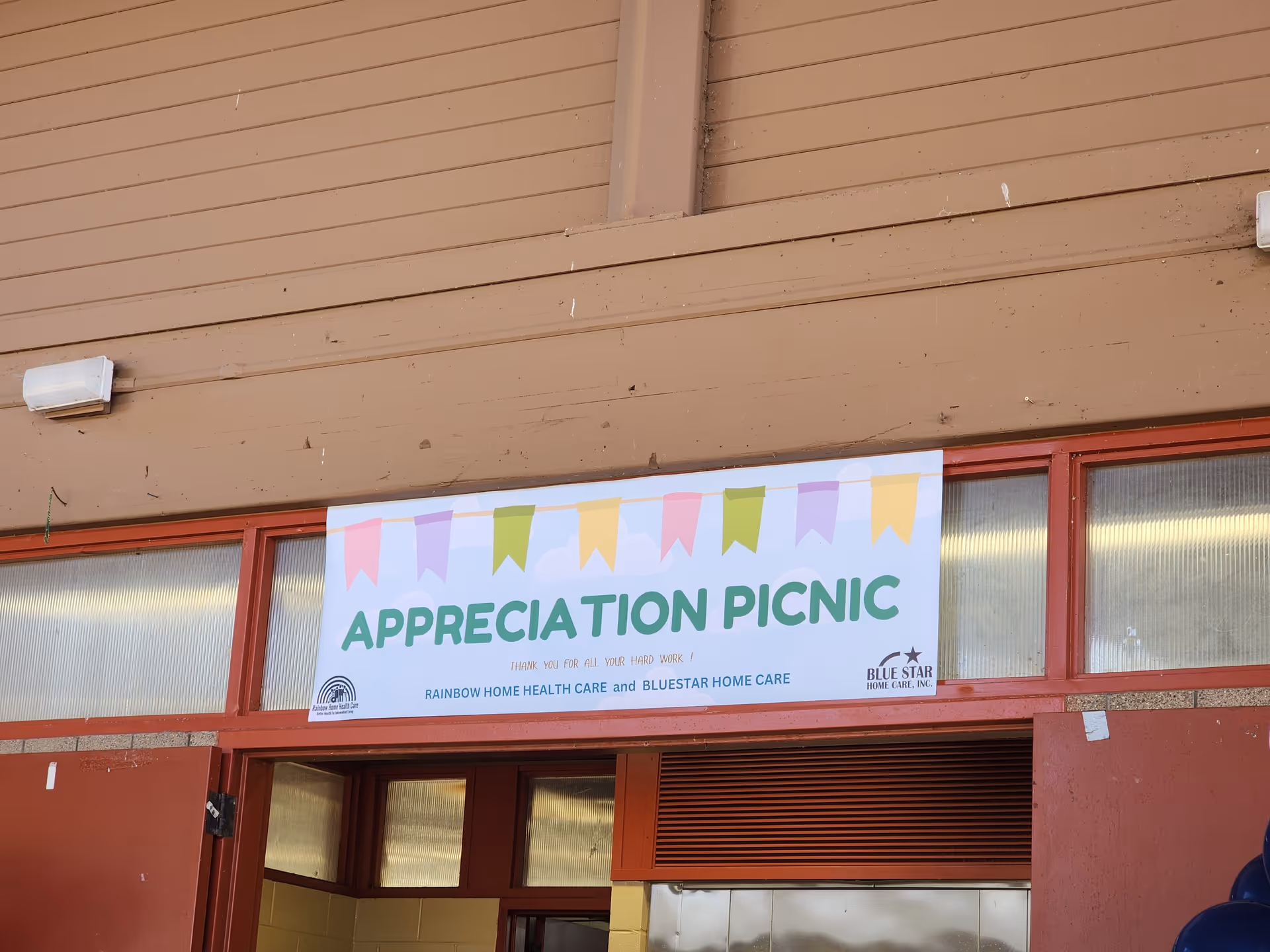 Brown building exterior with a colorful Appreciation Picnic banner above the entrance.