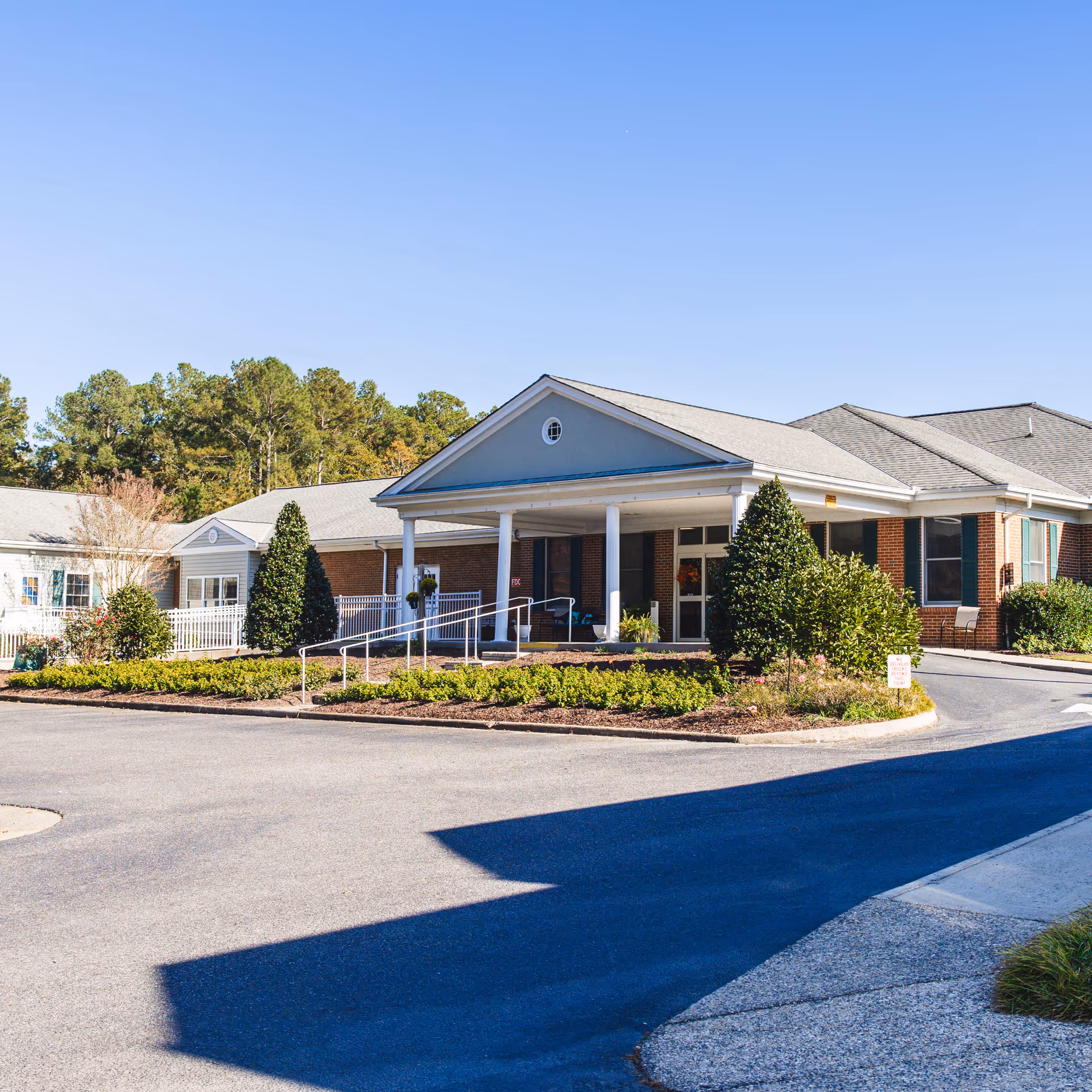 Front view of Commonwealth Senior Living at Gloucester House, entrance and landscaped grounds visible.