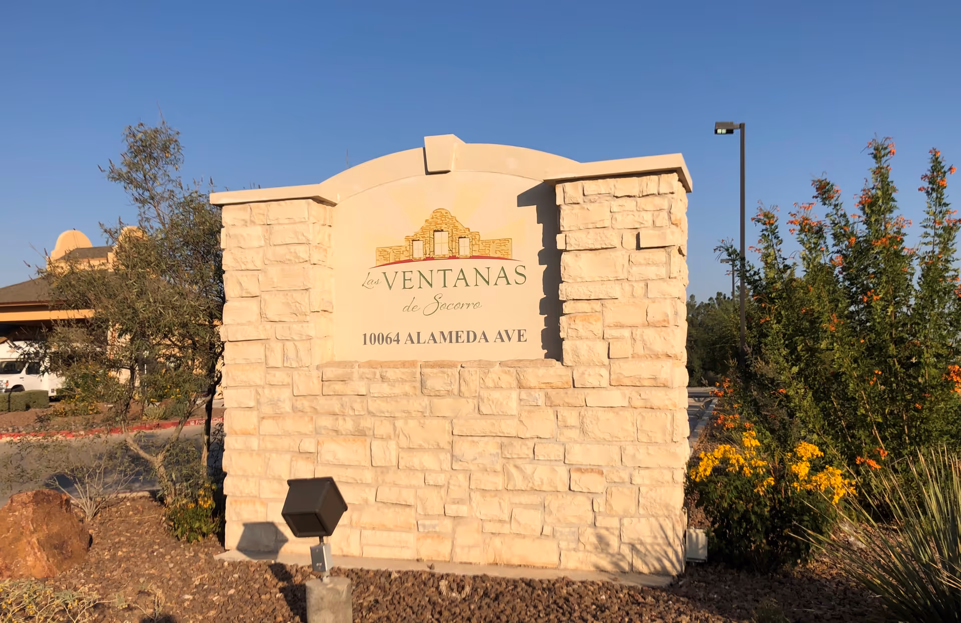 The entrance sign for Las Ventanas de Socorro at 10064 Alameda Ave surrounded by greenery.