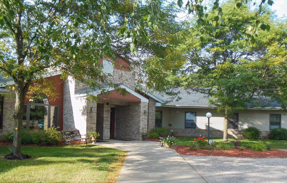 Front exterior of Chapel Valley II, brick entrance with a walkway, benches, and green landscaping.