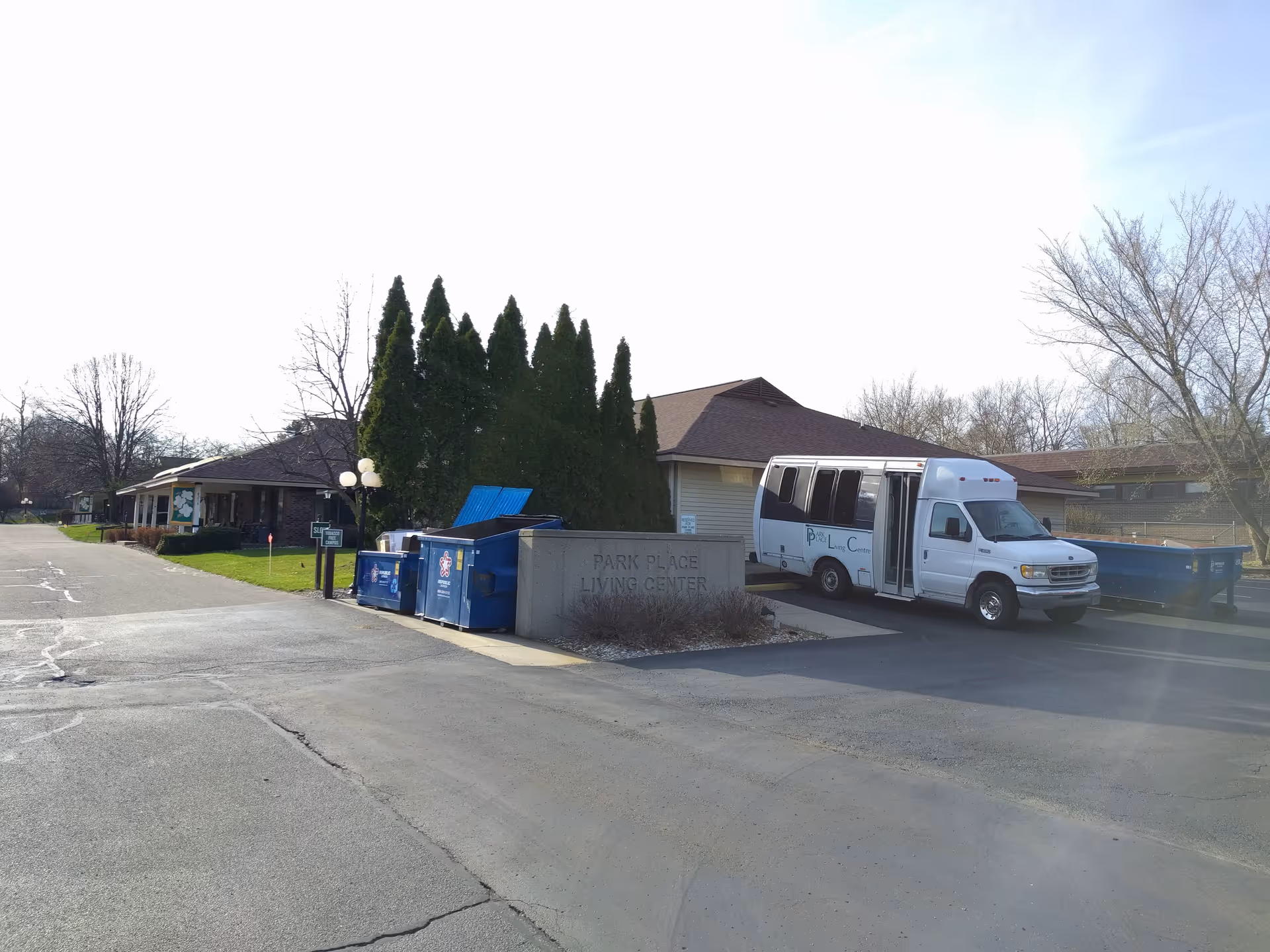 Exterior view of Park Place Living Center A with a bus parked nearby.