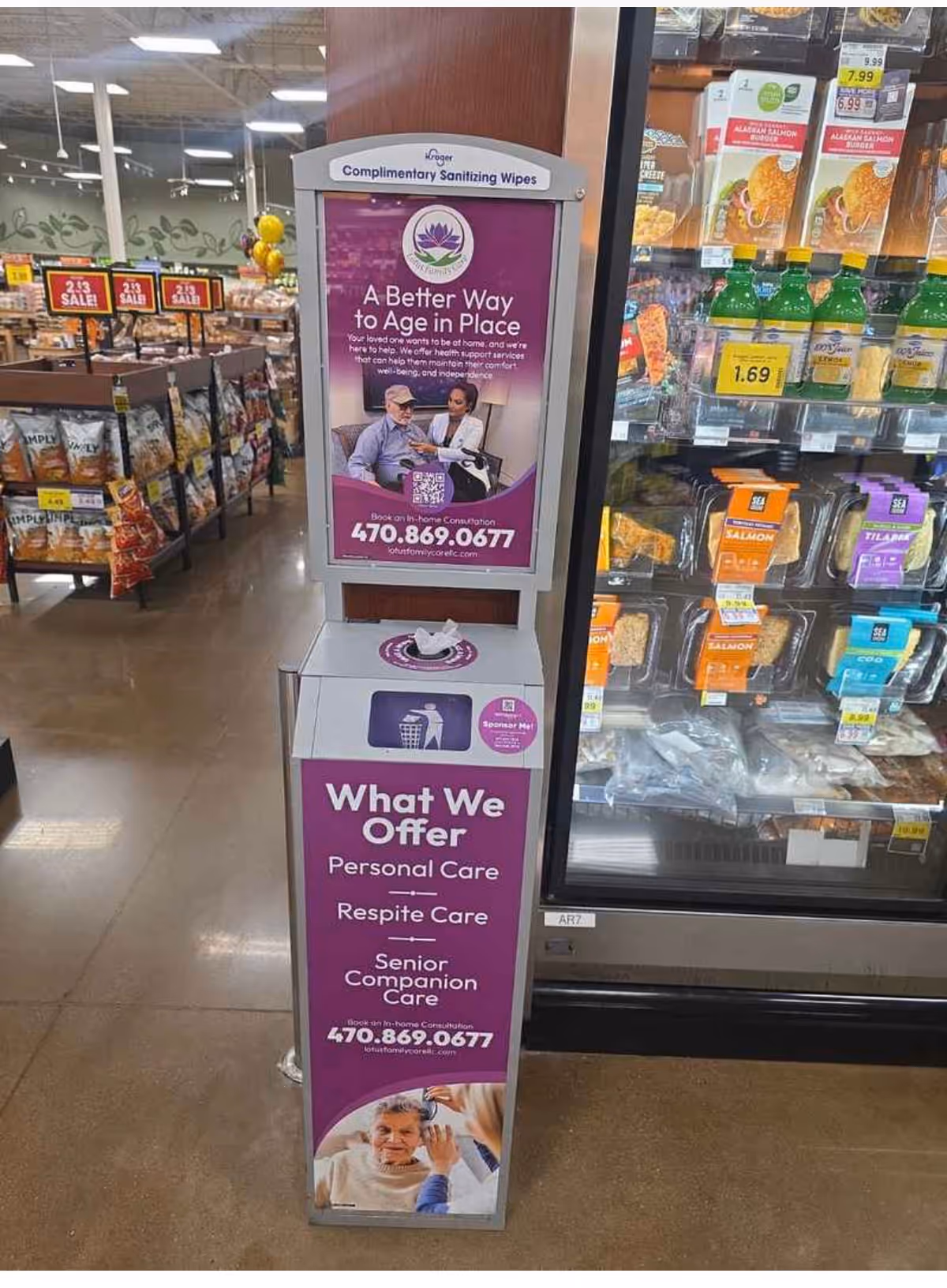 A purple promotional stand advertising senior care services inside a supermarket aisle