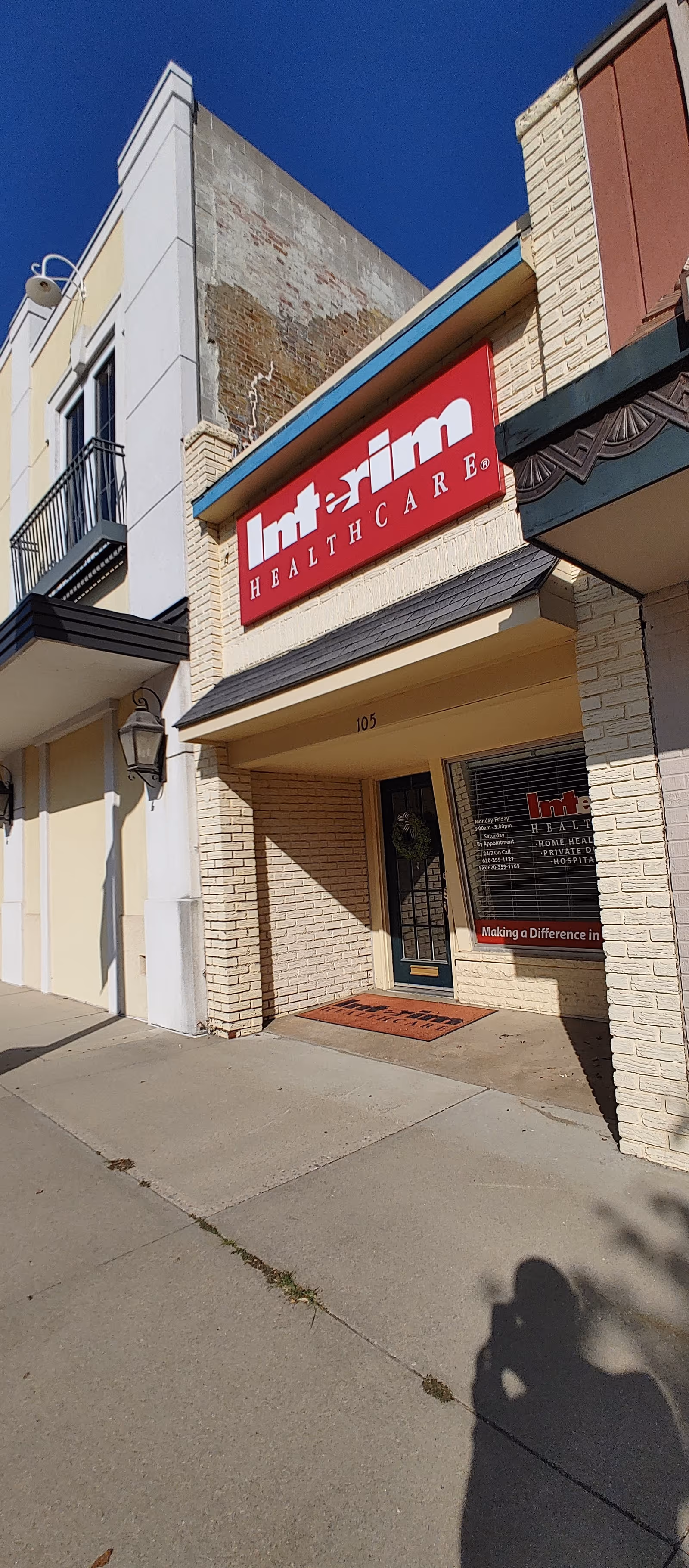 Exterior view of Interim HealthCare Wellington building with red sign and entrance