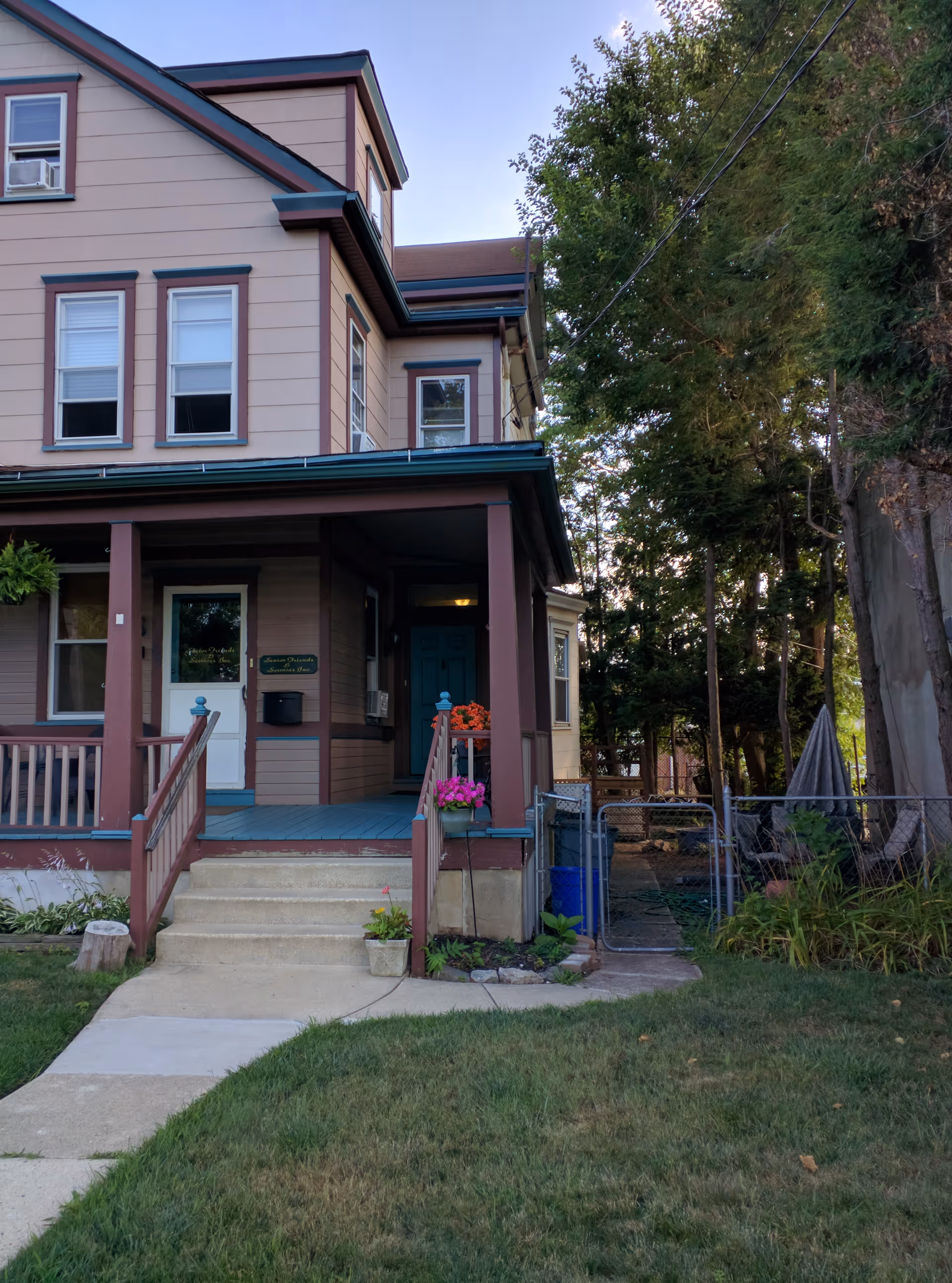 Front view of a two-story residential building with a covered porch and steps.
