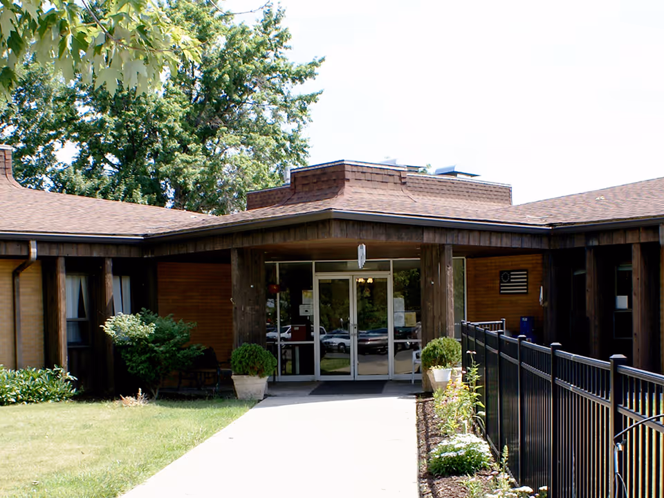 Crestwood Care Center entrance with glass doors, brick walls, and manicured landscaping.
