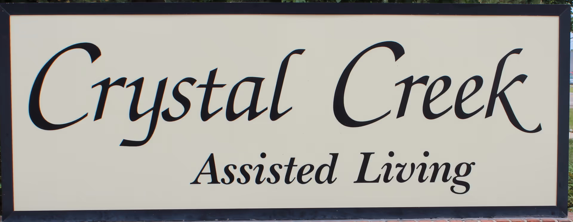 Crystal Creek Assisted Living sign mounted on a white panel.